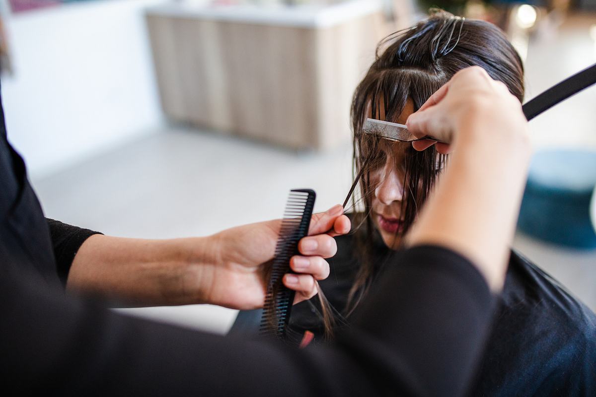 Frau werden Haare beim Frisur geschnitten (Themenbild)