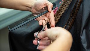 Frau sitzt beim Friseur und bekommt die Haare geschnitten - Foto: iStock/ Bota Sorin
