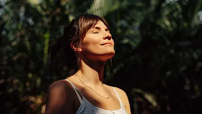 Frau mit dunklen Haaren steht in der Sonne - Foto: iStock/ miniseries Frau mit dunklen Haaren steht in der Sonne - Foto: iStock/ miniseries