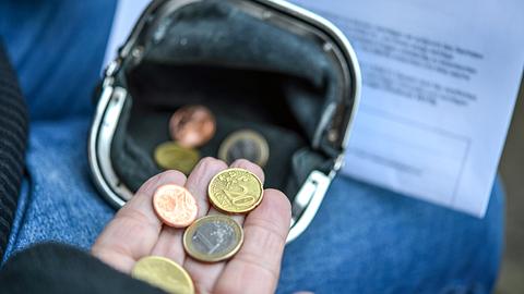 Frau zählt einige Euro und Cents Münzen in der Hand, Geldbörse und Mahnbrief - Foto: Karl-Hendrik Tittel/iStock