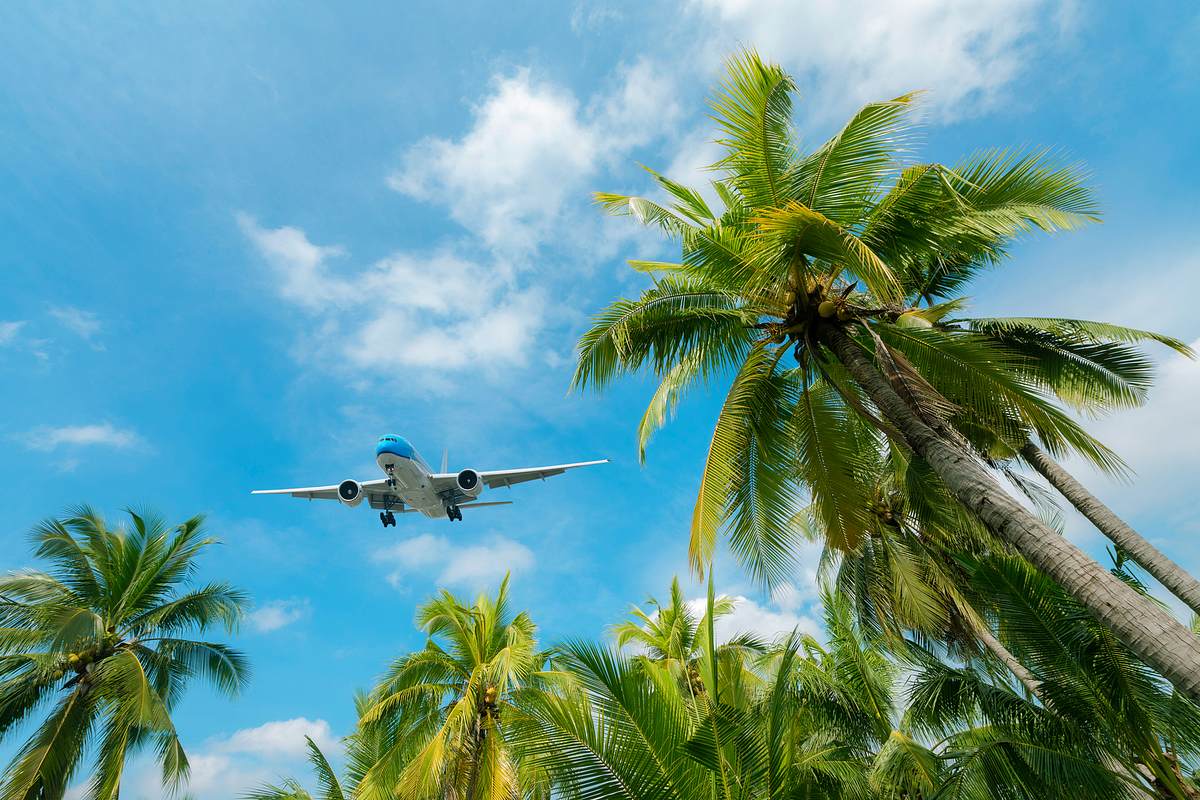 Flugzeug im Landeanflug auf tropisches Urlaubsziel