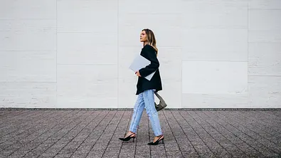 Frau mit schwarzer Jacke, blauer Jeans und schwarzen High Heels - Foto: iStock / FreshSplash