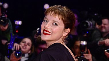Die Schauspielerin Jella Haase steht auf dem Roten Teppich und lächelt in die Kamera. - Foto: Getty Images / John Macdougall