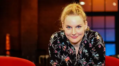 Judith Holofernes blickt in einem Studio direkt in die Kamera und trägt eine schwarze Bluse mit floralem Muster. - Foto: IMAGO / Eibner