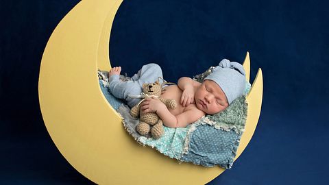 Baby liegt auf einem Mond (Themenbild) - Foto: katrinaelena/iStock