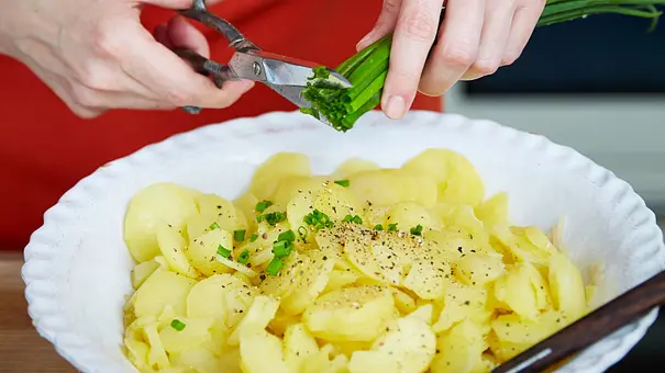 Frau, die Kartoffelsalat zubereitet. - Foto: Bauer Media Group