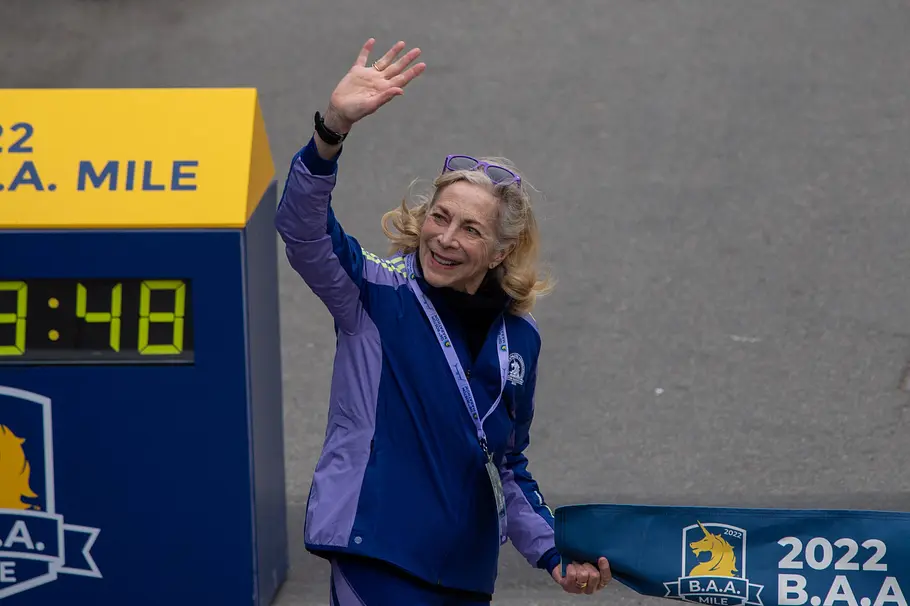 Kathrine Switzer winkt der Menge lächelnd auf einer Marathonstrecke zu