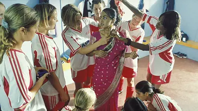 Hauptdarstellerin Jess im Sari mit ihren Freundinnen im Trikot - Foto: IMAGO / United Archives
