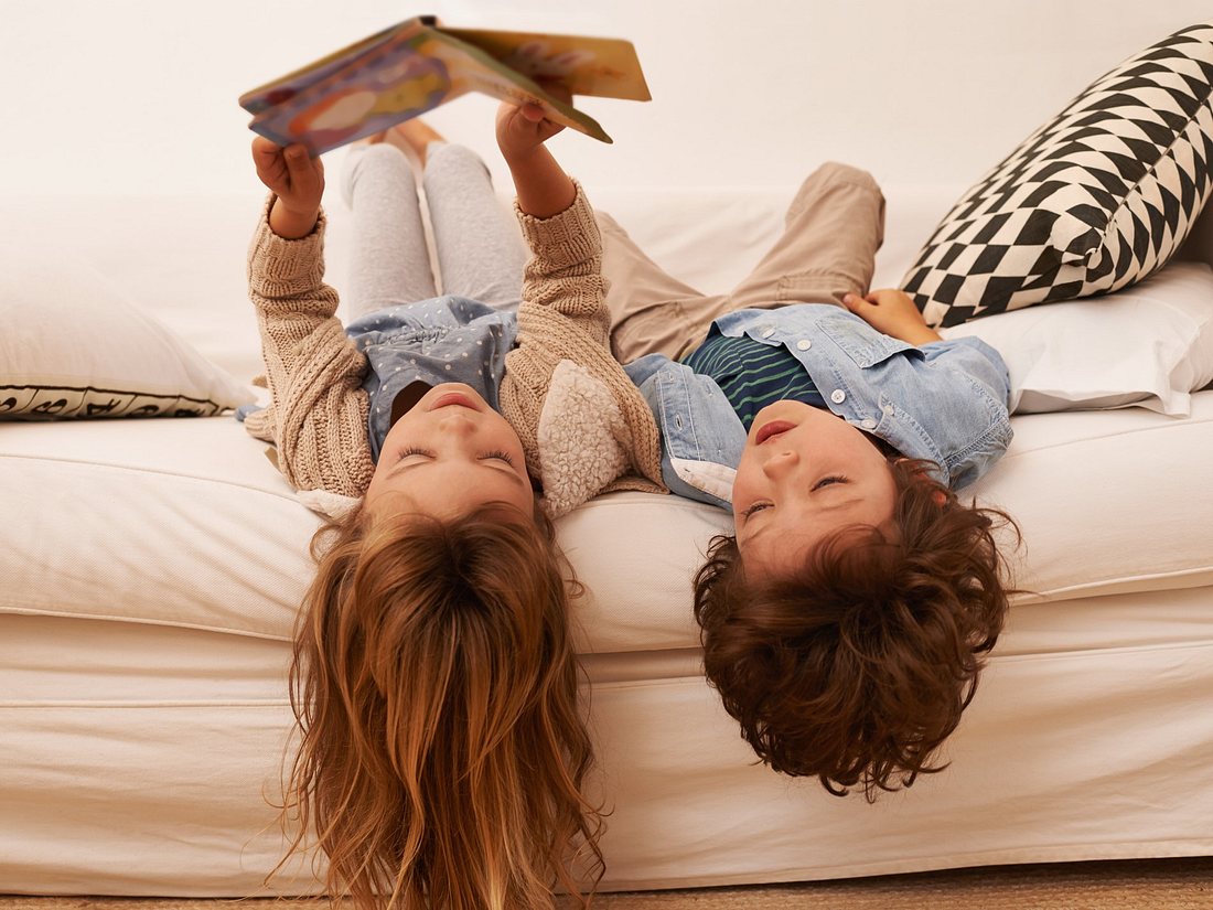 Kinder lesen Kinderbuch Klassiker auf Sofa