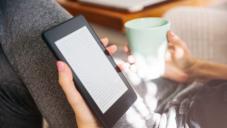 Frau liest eines der Kindle-Bücher - Foto: iStock/boggy22