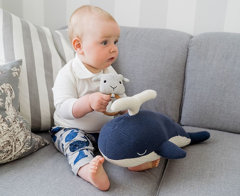 Baby mit Greifling auf dem Sofa