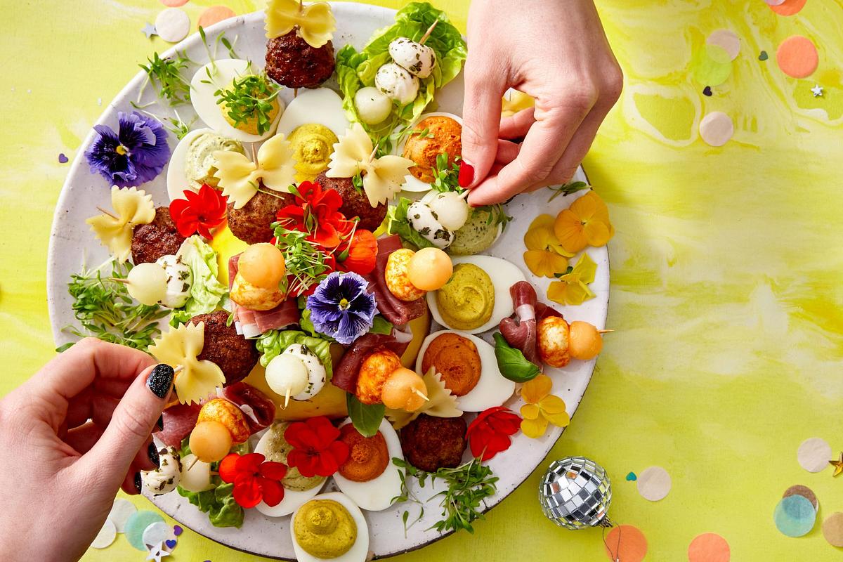 Kleine Snackplatte mit Regenbogen-Eiern, Mini-Fleischbällchen und Melonenspießen