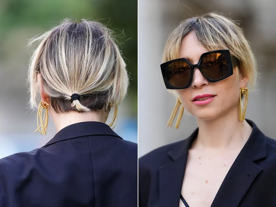Eine Frau trägt zur Sonnenbrille einen kleinen Pferdeschwanz und einen Hidden Untercut.