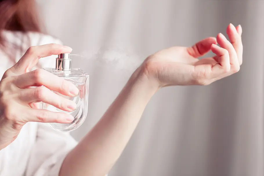 Langanhaltende Parfums Frau sprüht sich Parfum aufs Handgelenk