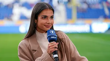 ARD-Reporterin Lea Wagner mit Mikrofon im Stadion bei einer Fußballübertragung - Foto: IMAGO / foto2press