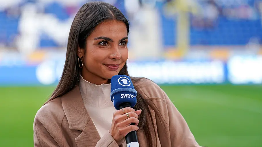 Lea Wagner bei einem Einsatz als ARD-Sportreporterin im Stadion ARD-Reporterin Lea Wagner mit Mikrofon im Stadion bei einer Fußballübertragung