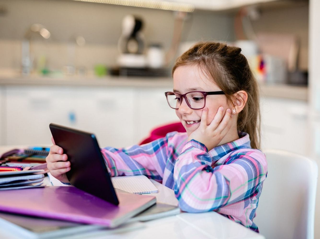 Schulmädchen sitzt für Lerncomputer und macht ihre Hausaufgaben