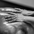 Frauen-Hände ölen sinnlich einen Männerrücken zur Vorbereitung auf eine Lingam-Massage ein. - Foto: iStock / microgen