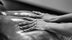 Frauen-Hände ölen sinnlich einen Männerrücken zur Vorbereitung auf eine Lingam-Massage ein. - Foto: iStock / microgen