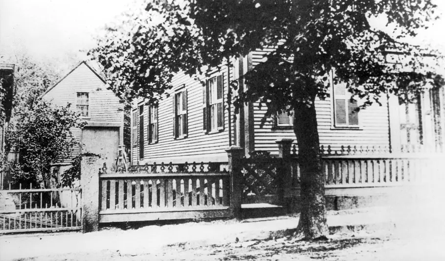 Lizzie Bordens 1892 Ein Haus steht hinter einem Baum (schwarz-weiß Fotografie). Es handelt sich um das Haus der Bordens, in dem die Morde geschahen.