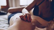 Mann liegt auf dem Rücken im Bett und Frau liegt halb auf ihm drauf, wobei ihre Hand auf seiner Brust ruht - Foto: istock/ South_agency