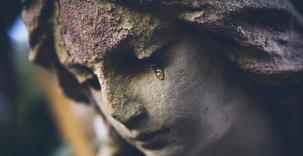 Ein steinerner Engel auf dem Friedhof weint. 