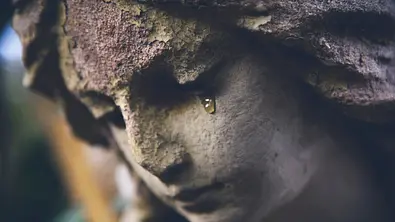 Ein steinerner Engel auf dem Friedhof weint.  - Foto: Iurii Kuzo / iStock
