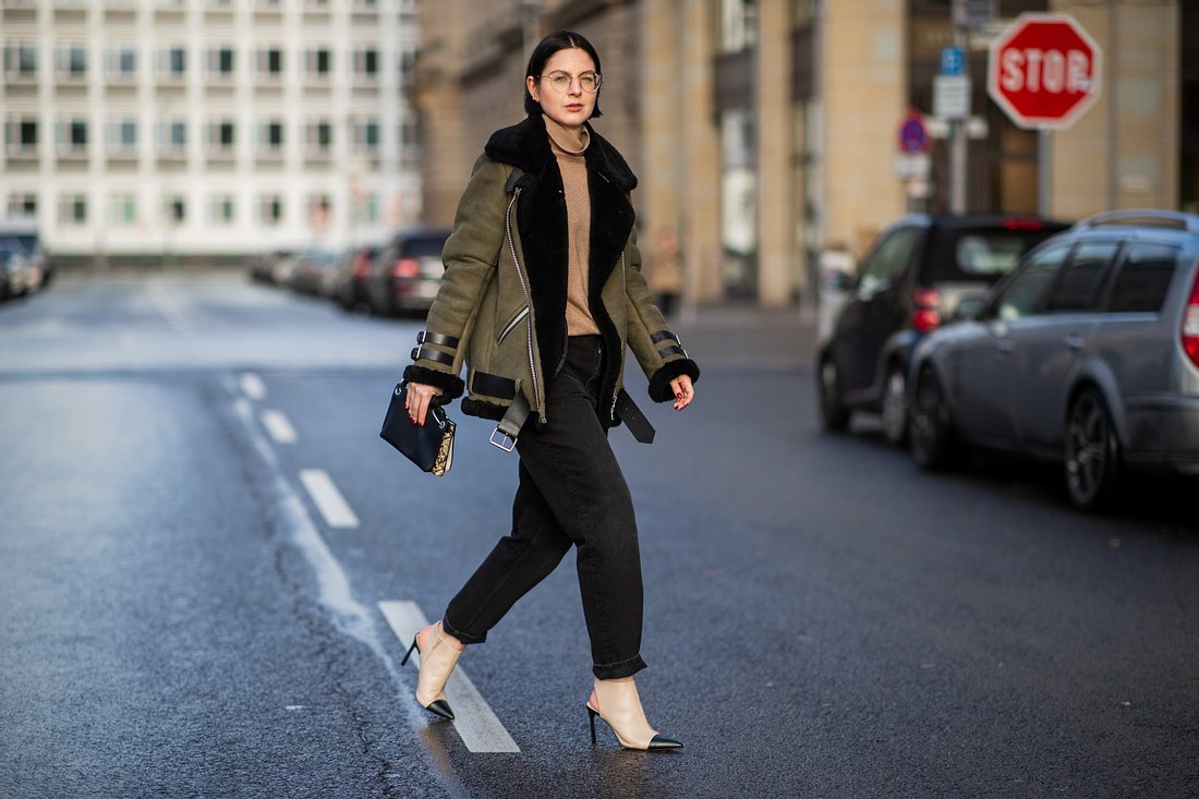 Mom Jeans outfit winter kombis mit must have potenzial schwarze jeans Frau mit Pilotenjacke und schwarzer Mom Jeans