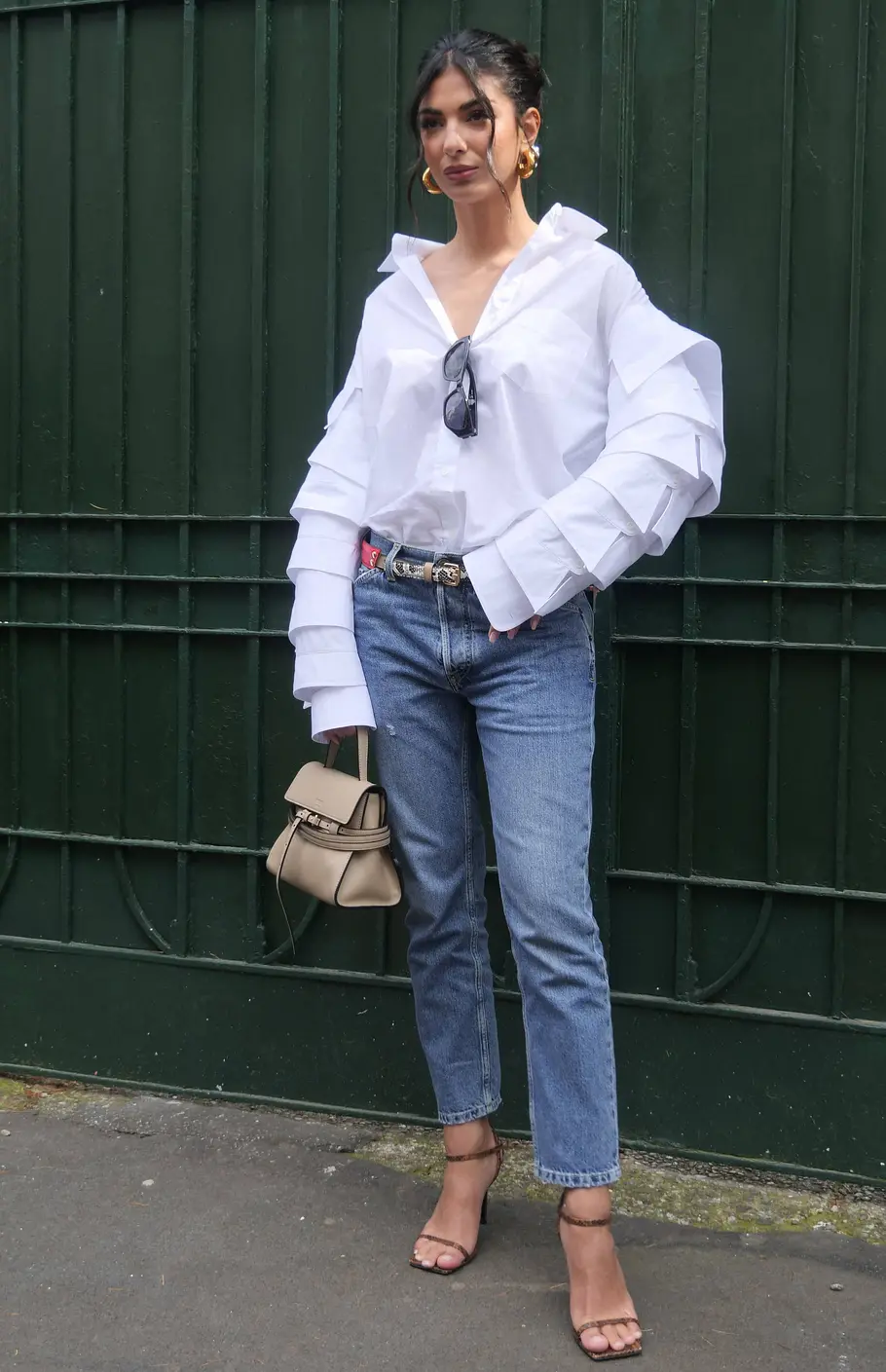Mom Jeans stylen: Frau auf der Straße in einer Mom Jeans und mit einer weißen Bluse