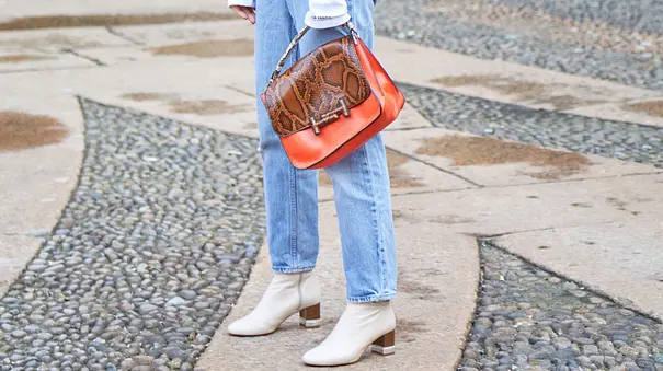 Mom Jeans stylen: Frau in Jeans und einem grünen Blazer auf der Straße - Foto: IMAGO / Dreamstime