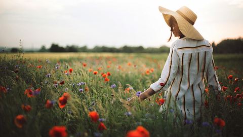 Frau geht durch Blumenwiese - Foto: iStock/Bogdan Kurylo