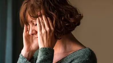 Frau, die müde ihre Schläfen massiert. - Foto: NickyLloyd/iStock