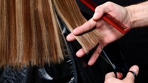 Dunkles Haar wird mit einer Schere geschnitten.  - Foto: powerofforever/iStock (Themenbild)