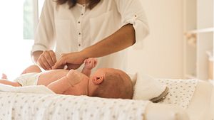 Mutter wickelt das Baby auf dem Wickeltisch - Foto: iStock/Trendsetter Images