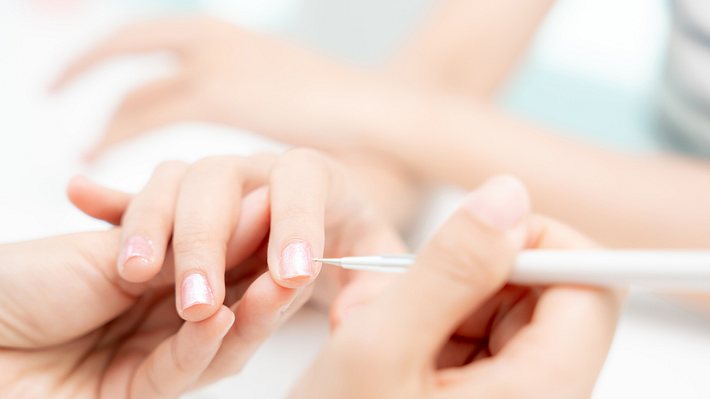 Frau bekommt Behandlung im Nagelstudio (Themenbild) - Foto: Nuttawan Jayawan/iStock