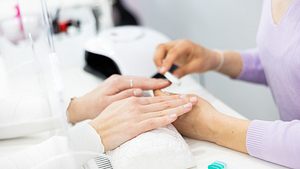 Frau im Nagelstudio lässt sich die Nägel machen (Themenbild) - Foto: JackF/iStock