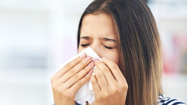 Frau niest in ein Taschentuch (Themenbild) - Foto: Yuri_Arcurs/iStock