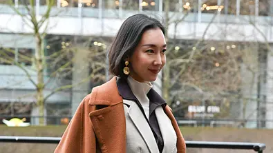 Ohrringe-Trends 2026: Streetstyle mit einer Frau in einem camelfarbenen Mantel - Foto: ddp