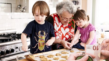 Nur gegen Geld! Oma will fürs Babysitten ihres Enkels bezahlt werden (Symbolbild). - Foto: Getty Images/Jenny Elia Pfeiffer/ Hinterhaus Productions