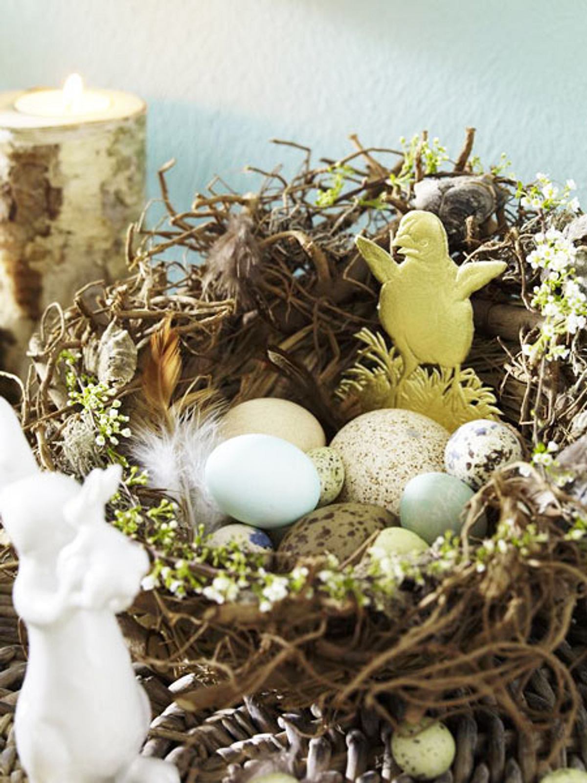 Natürliche Ostern kannst du dir mit dem DIY-Osternest aus Zweigen und Federn ins Haus holen