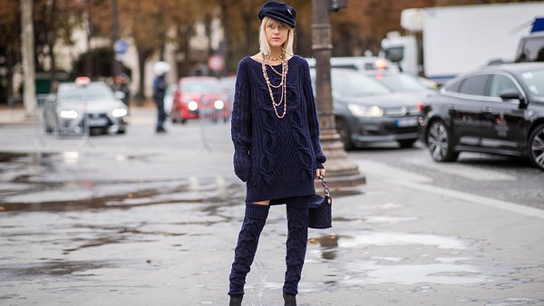 Blonde Frau mit Strickkleid und Overknee Strümpfen - Foto: Christian Vierig/ Getty Images