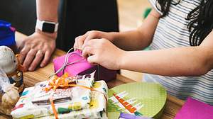 Kind öffnet personalisierte Geschenke für Kinder - Foto: iStock/golero