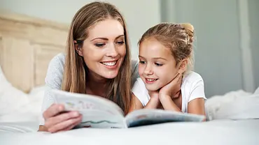 Kind liest personalisiertes Kinderbuch mit Mutter - Foto: istock/shapecharge Kind liest personalisiertes Kinderbuch mit Mutter - Foto: istock/shapecharge