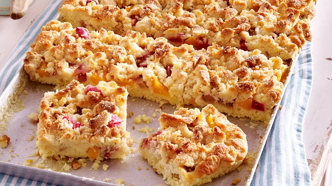 Leckerer Pfirsichkuchen vom Blech ist ein Highlight auf der Kaffeetafel. - Foto: Bauer Media Group
