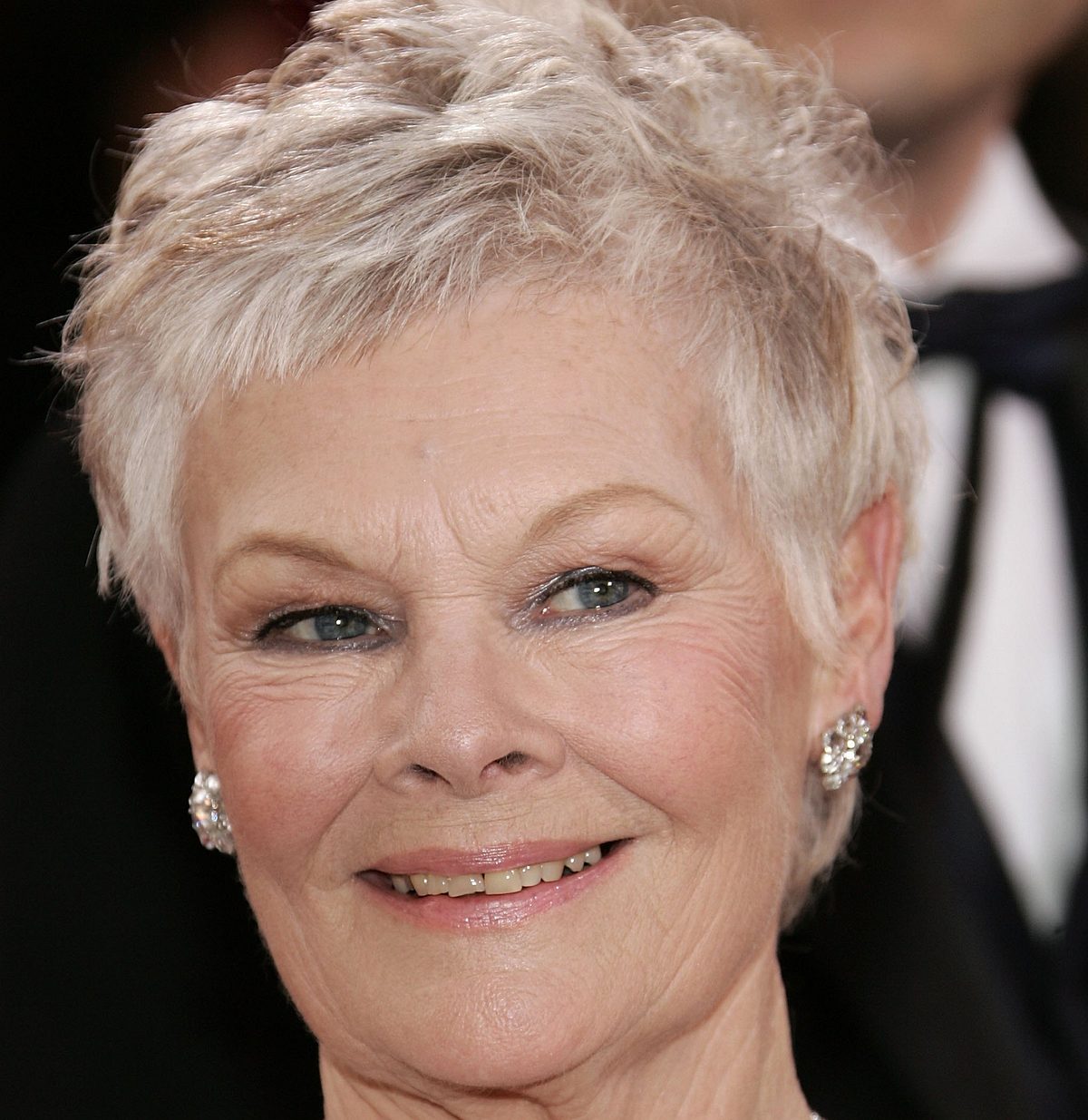 1. Klassischer Pixie Cut für Frauen ab 60 mit grauen Haaren Schauspielerin Judi Dench trägt einen strukturierten Pixie Cut.