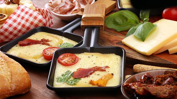 Raclette Pfännchen mit Käse, Kirschtomaten, Schinken, Basilikum - Foto: Symbolbild: beats3/iStock