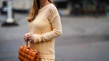 Kleid mit Pullover kombinieren: Wir gehen elegant durchs Schmuddelwetter! - Foto:  Edward Berthelot/Getty Images