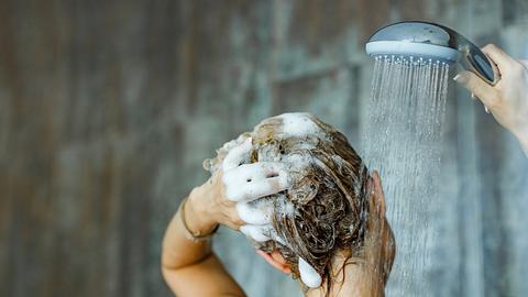 Frau wäscht Haar mit Reinigungsshampoo - Foto: skynesher / iStock