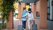 Zwei Frauen mit Rollkoffer - Foto: iStock/Nikola Ilic