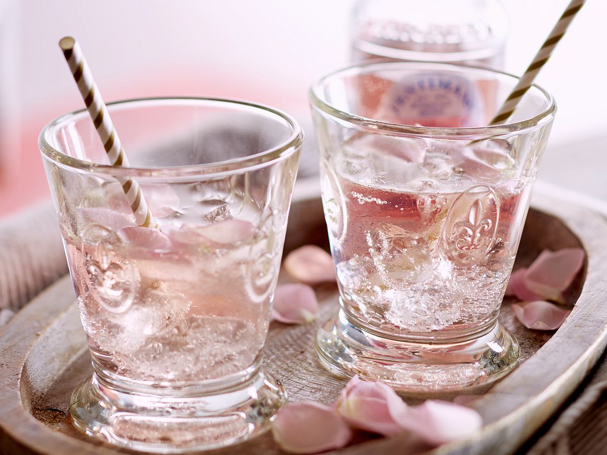 Rosen-Vodka-Spritz mit Rosenblüten verziert